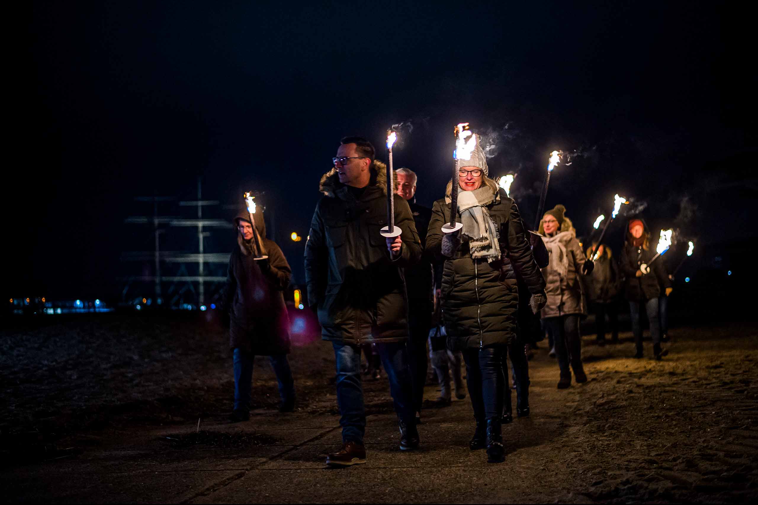 Gruppe Menschen bei Fackelwanderung am Strand in Travemünde